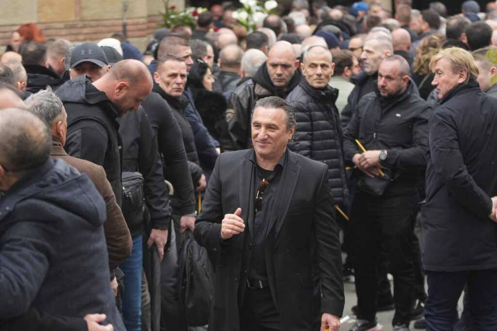 Student stoji pored krsta sa lisicama na nogama