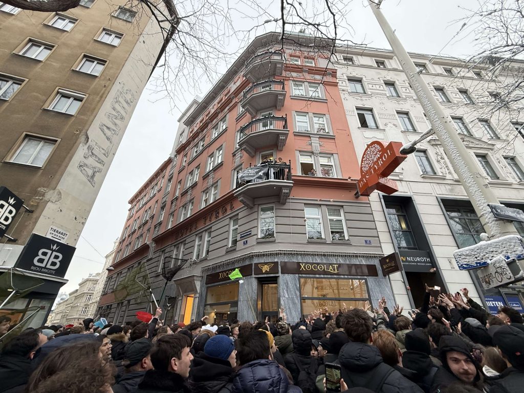 Okupljena masa ljudi ispod balkona na Mariahilfer Straße dok pokušavaju uhvatiti novčanice