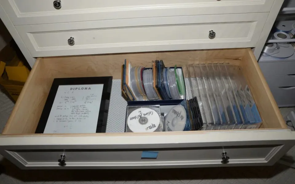 Otvorena ladica stola sa više CD-ova i diskova poredanih unutra